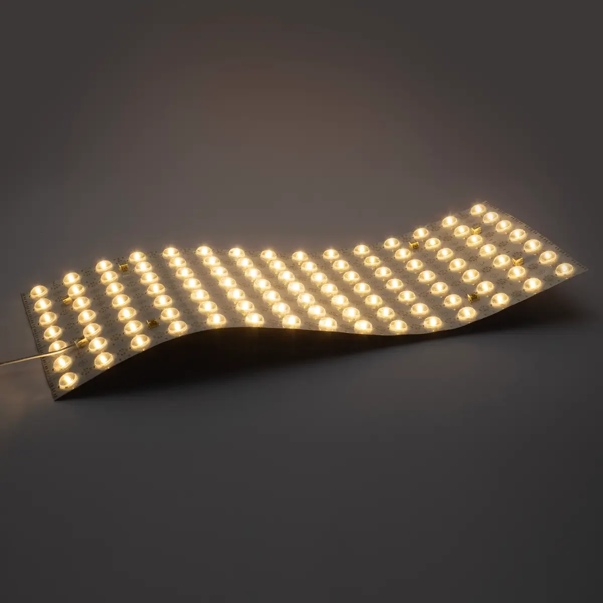 Lámina LED flexible 24V 21W encendida y curvada con iluminación blanca uniforme mediante ópticas de 175°